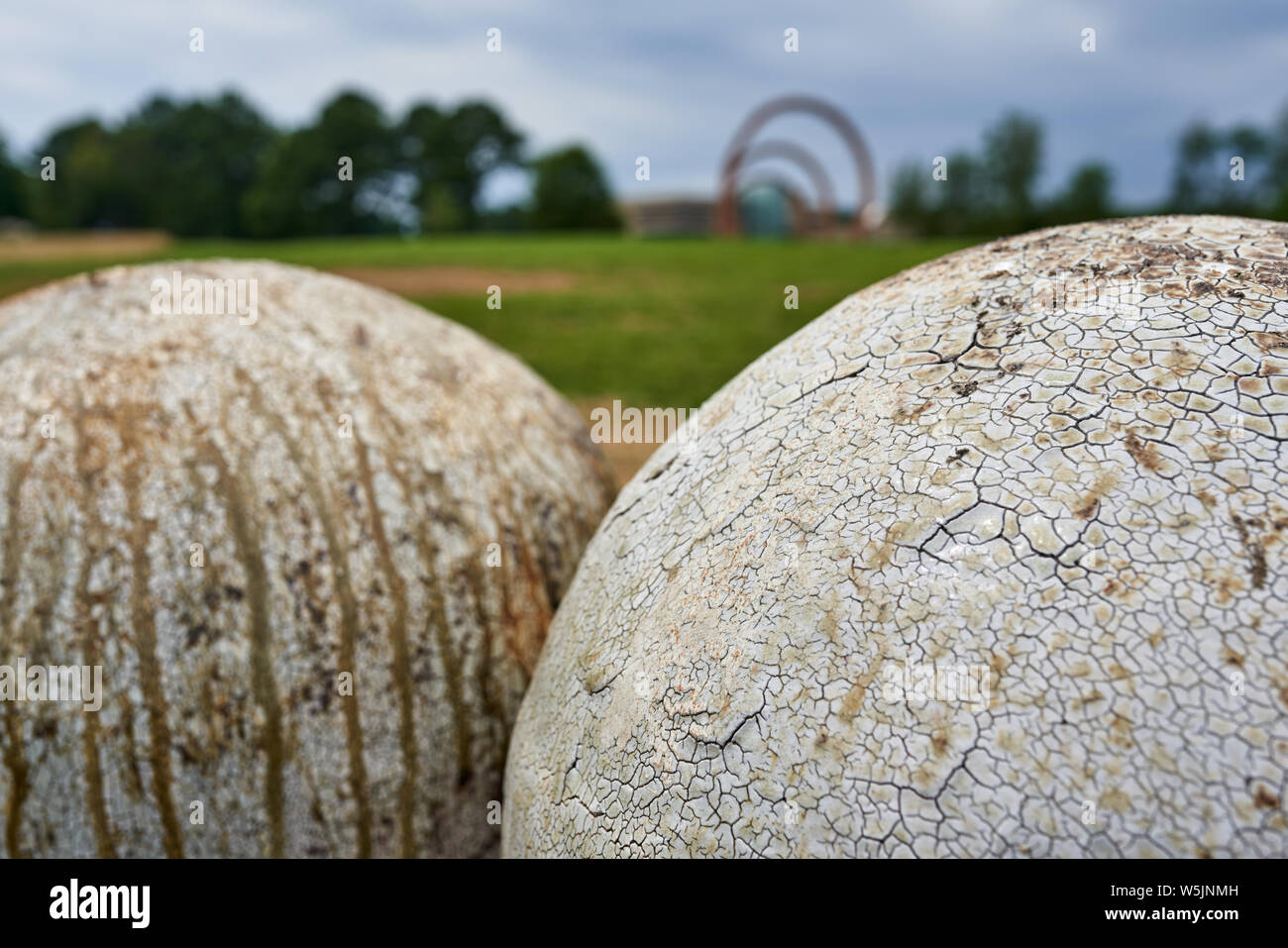 A view Daniel Johnston`s `Untitled` with Thomas Sayre`s `Gyre` visible in the background at the sculpture garden at NCMA in Raleigh NC Stock Photo